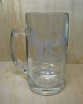 Clear glass mug with engraved design on a wooden surface