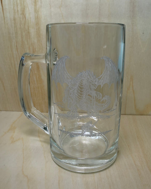 Clear glass mug with engraved design on a wooden surface